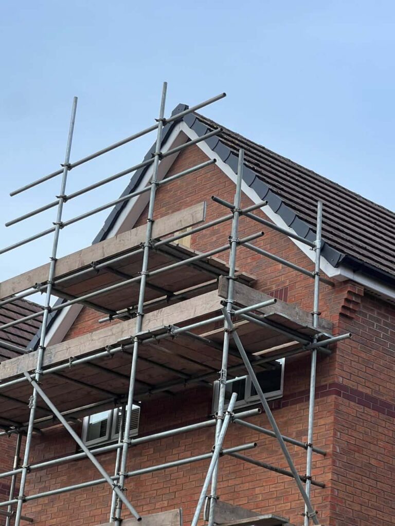 This is a photo of a roof which has just been repaired. There is a scaffold located at the gable end for access onto the roof. Works carried out by Sedgley Roofing Repairs